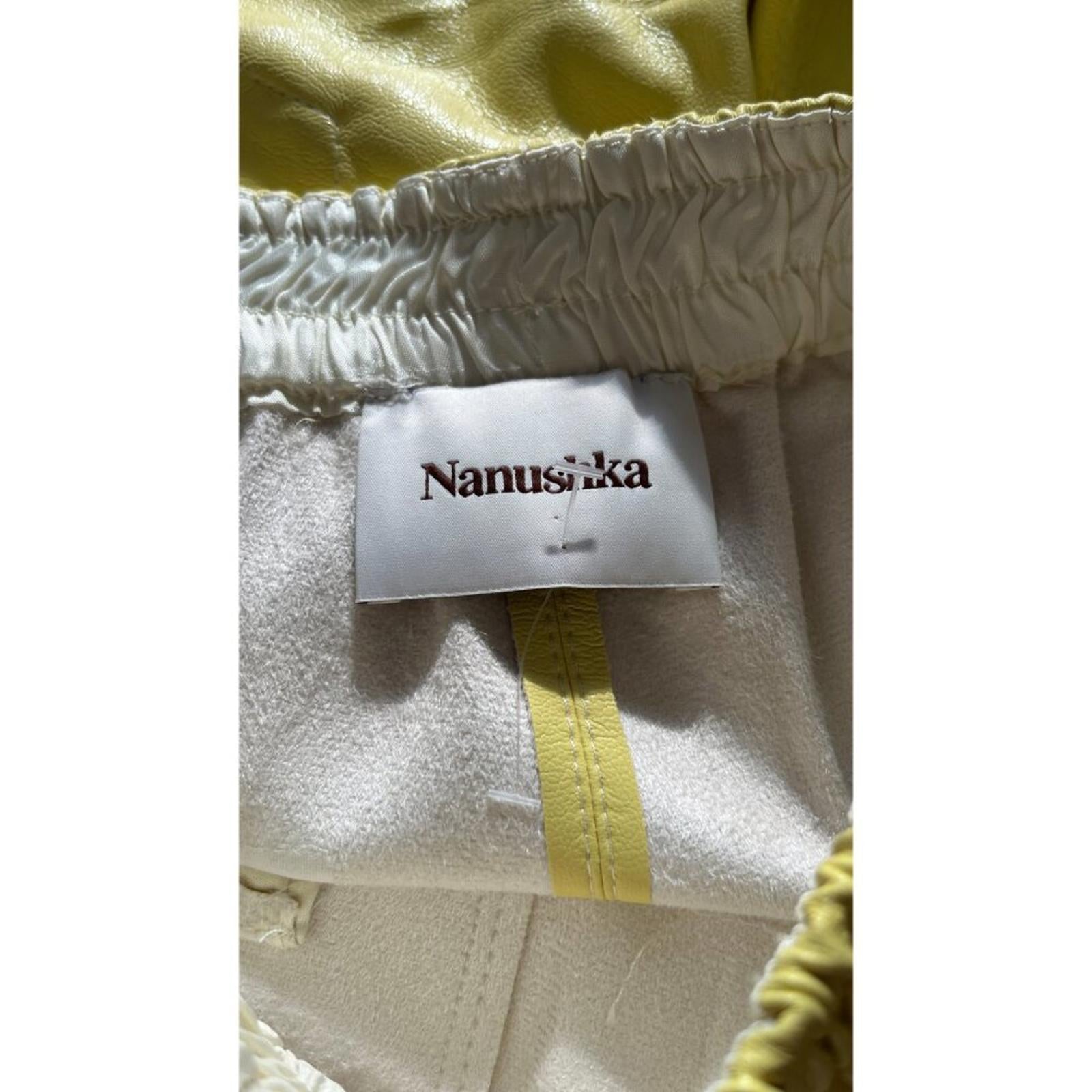 NANUSHKA YELLOW VEGAN LEATHER ELASTIC WAIST SHORTS tag detail showing brand label in high-quality vegan leather.