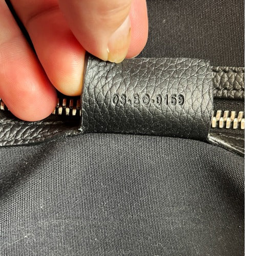 Date code 03-B0-0159 tag on the interior of the CHRISTIAN DIOR KIM JONES BLACK OBLIQUE MONOGRAM TOTE BAG.