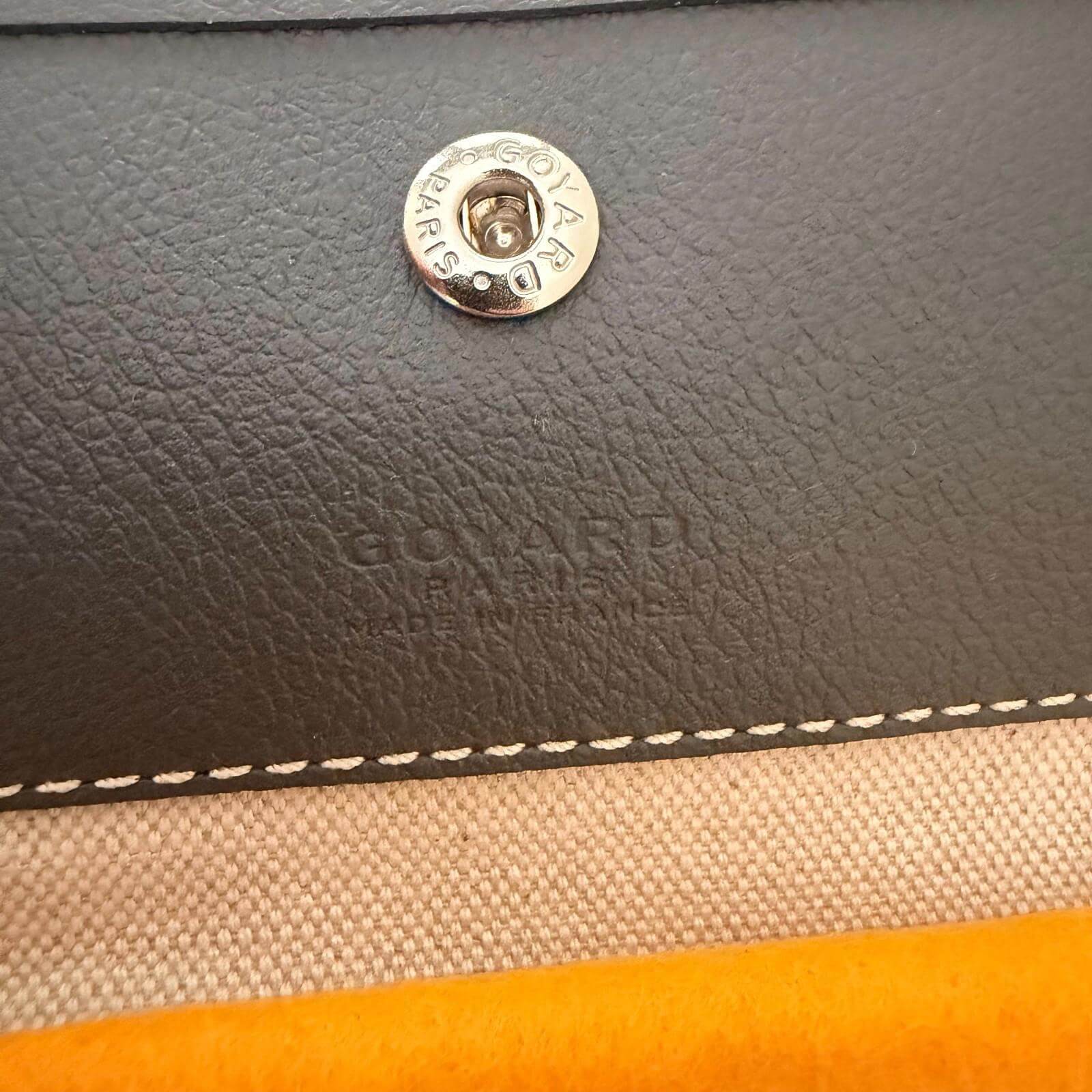 Close-up of the interior snap button and embossed logo of Goyard St. Louis bag GM- Goyardine.