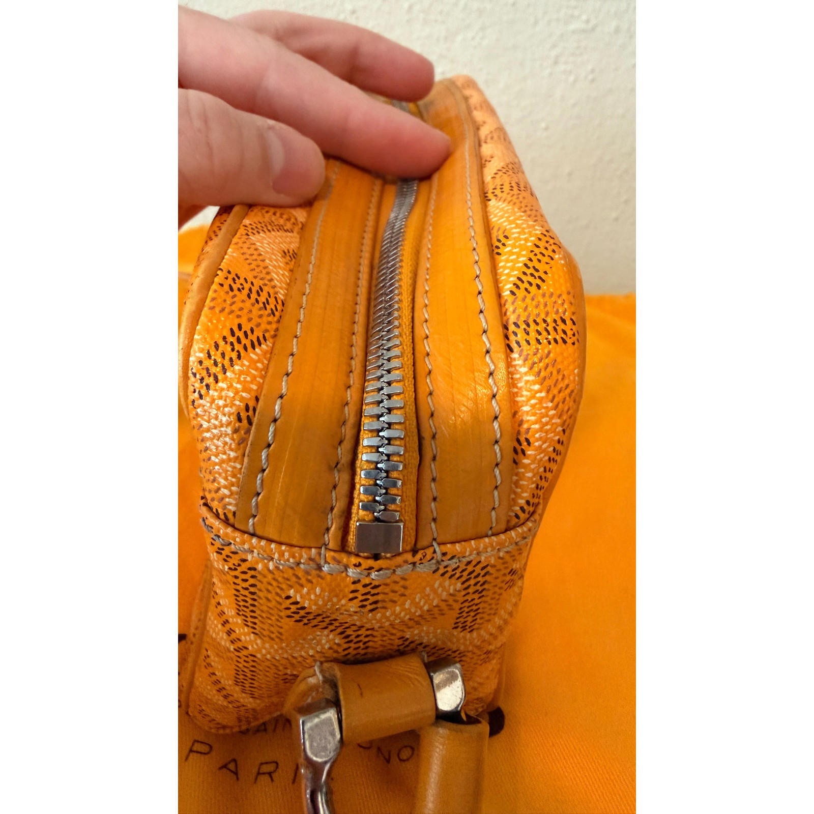 Goyard yellow Cap Vert crossbody bag close-up showing zipper detail and texture of Goyardine pattern.