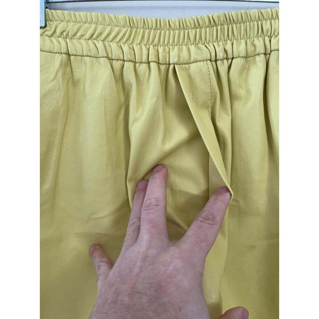 NANUSHKA YELLOW VEGAN LEATHER ELASTIC WAIST SHORTS showcasing the waistband and texture.