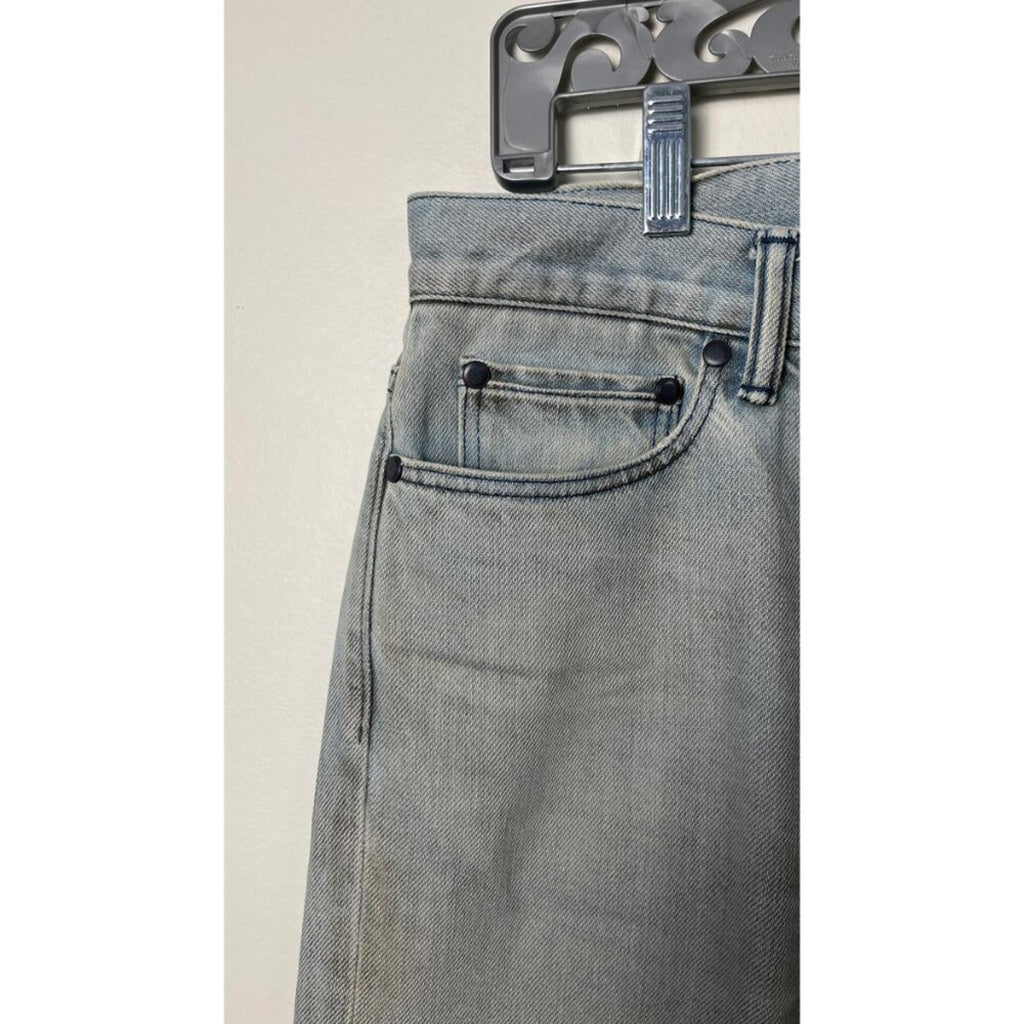 JOHN ELLIOTT THE CAST 2 SPRING DIRTY JEANS featuring factory staining and detailed stitching, hanging on a display