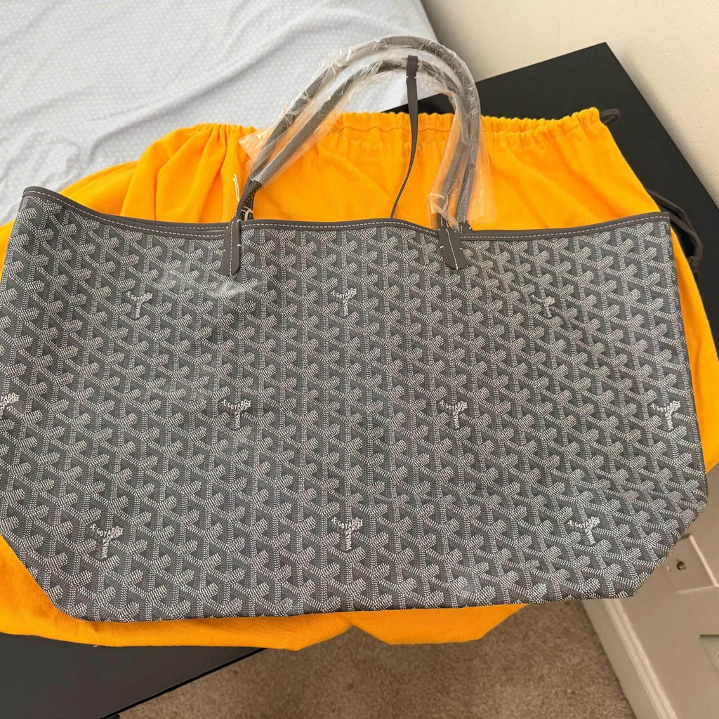 Goyard St. Louis bag GM- Goyardine displayed on a table with plastic coverings on handles and felt pouch.