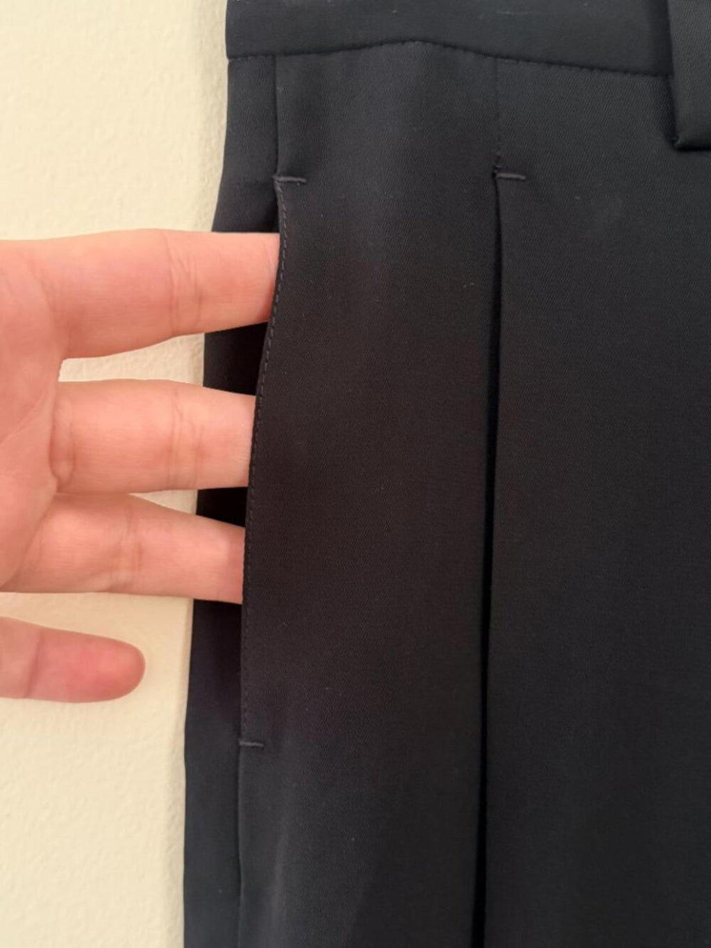 Detail view of TOM FORD BLACK DRESS SPECIAL OCCASION PANTS showing fabric and pleat with hand for scale.