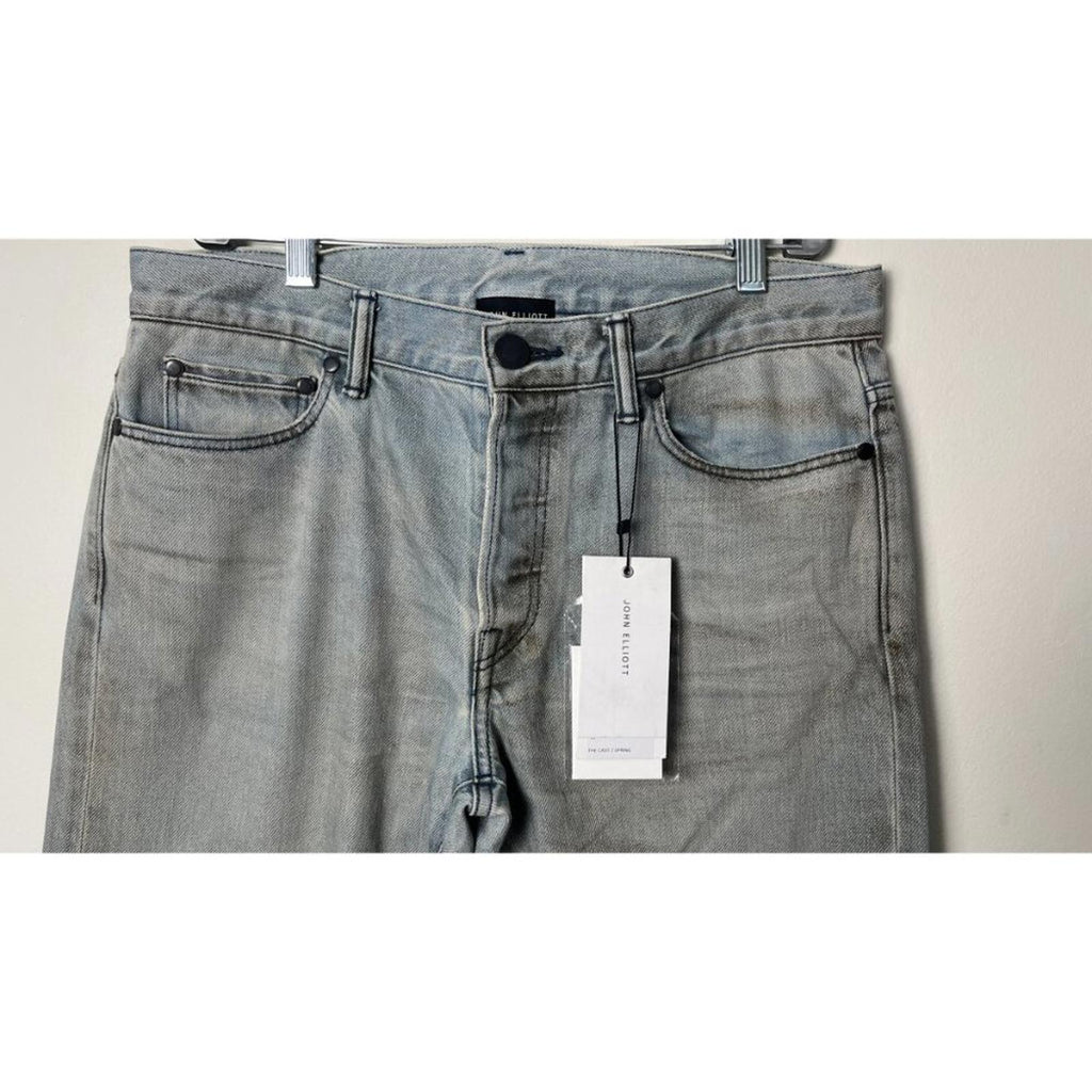 JOHN ELLIOTT THE CAST 2 SPRING DIRTY JEANS showing front view with hang tag, slim tapered leg, and factory distressing.