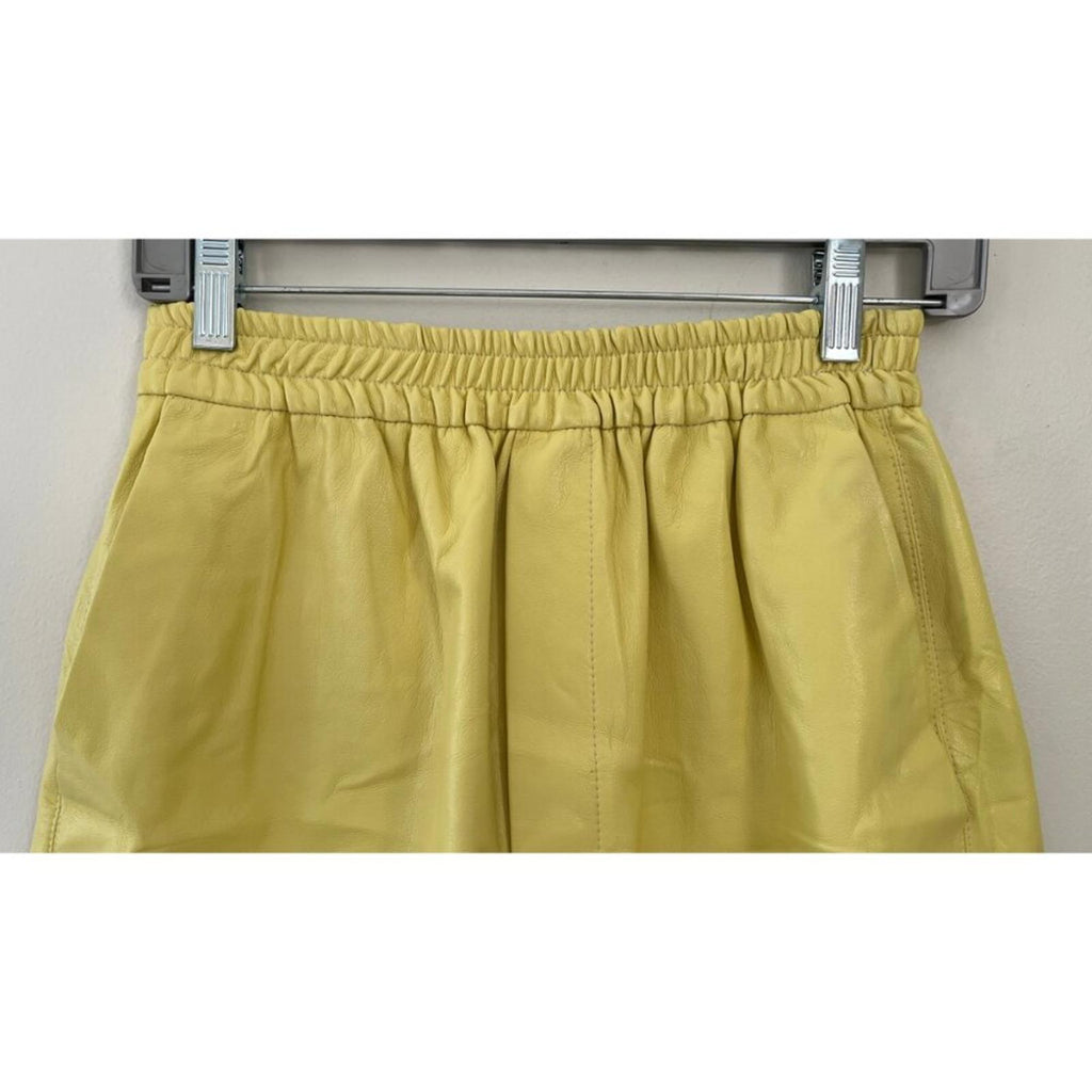 NANUSHKA YELLOW VEGAN LEATHER ELASTIC WAIST SHORTS close-up of waistband and fabric texture
