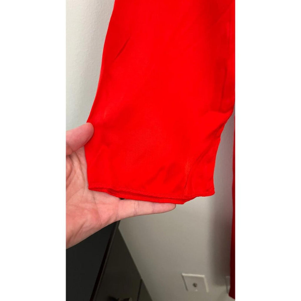Close-up of the sleeve of RAQUEL ALLEGRA RED GHOST RANCH MATTE RAYON SATIN DRESS in vibrant red color.