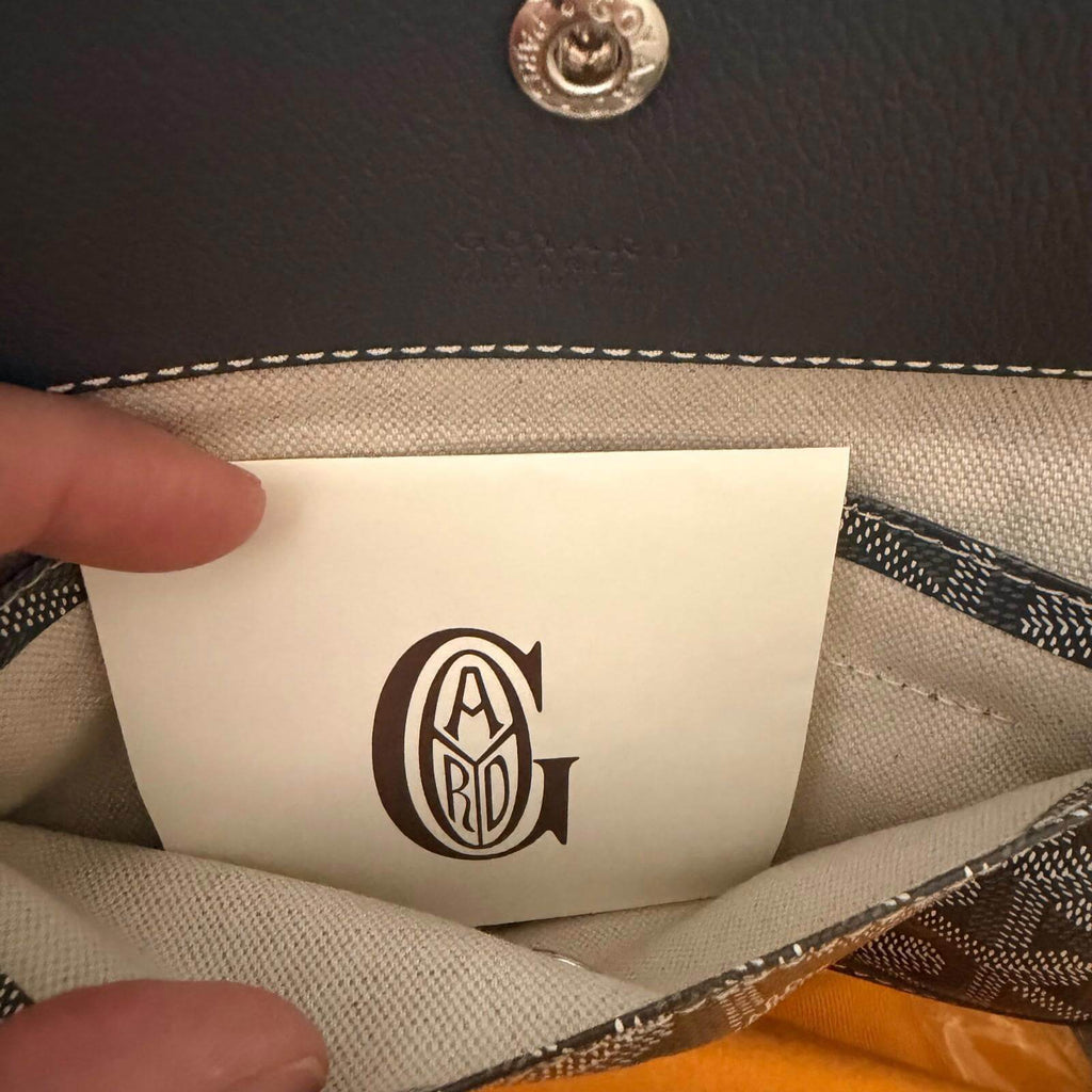 Interior view of Goyard St. Louis bag GM- Goyardine showing brand card and storage pouch.