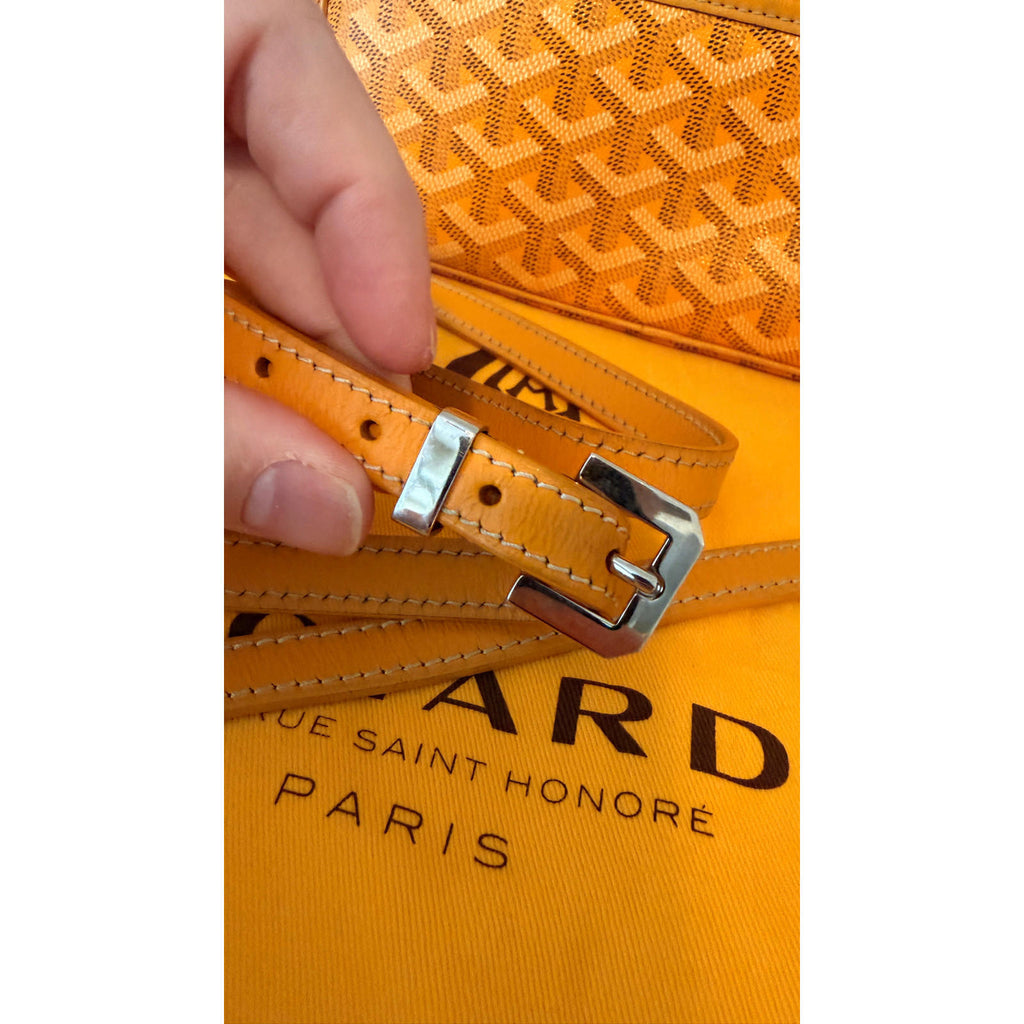 Close-up of the adjustable strap of the GOYARD YELLOW CAP VERT CROSSBODY BAG showcasing its buckle and yellow interior.