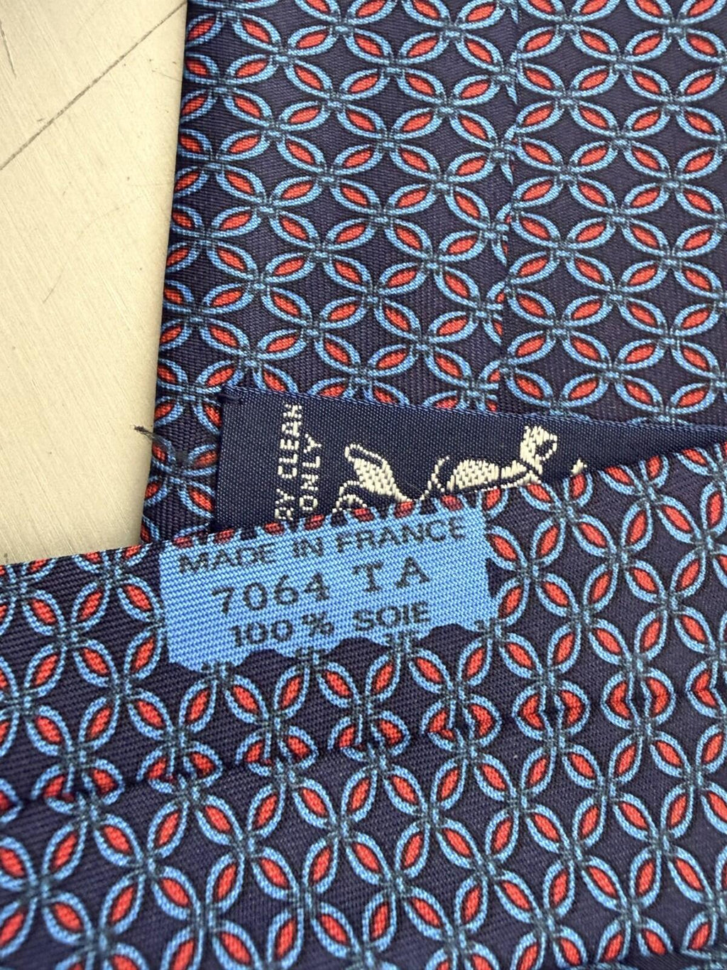 HERMES PARIS GEOMETRIC PRINT NECK TIE fabric detail showing intricate design and luxury brand label.