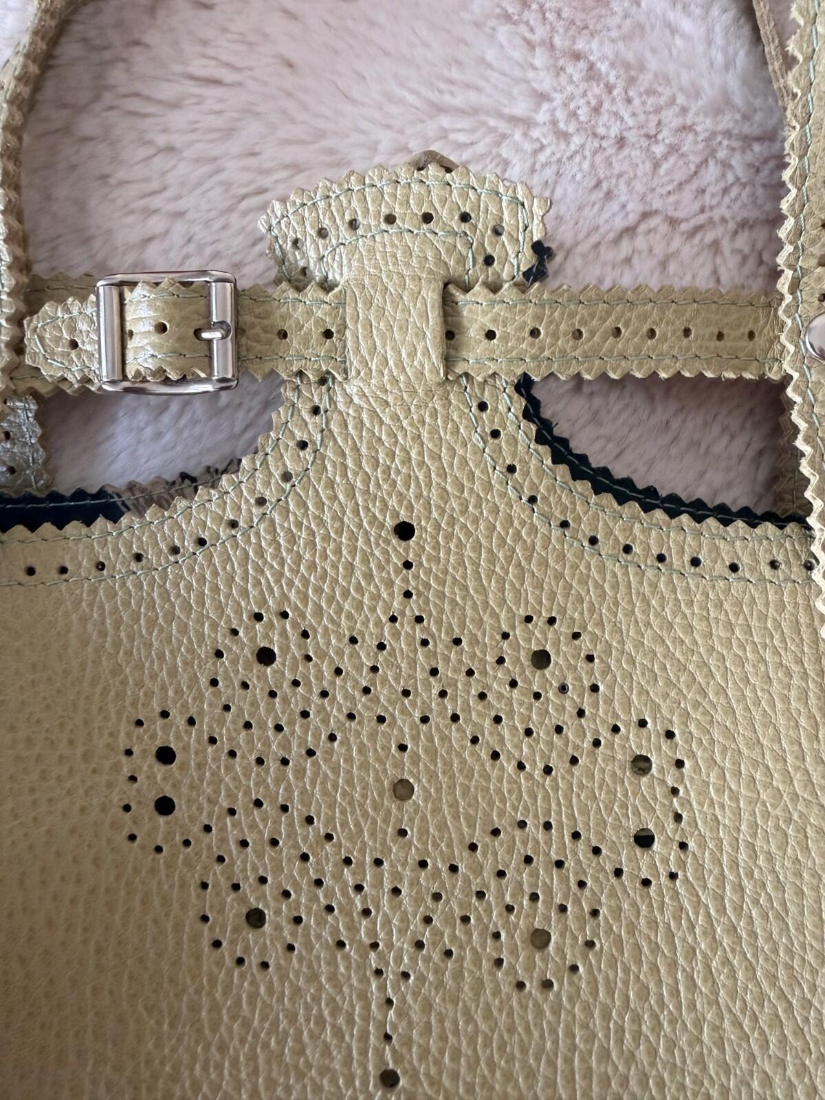 Close-up of the JAMIN PUECH DELICATE DETAIL HANDBAG showcasing intricate lace perforated design and vibrant chartreuse color.