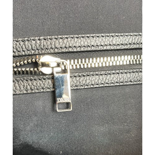 Close-up of the zipper detail on the CHRISTIAN DIOR KIM JONES BLACK OBLIQUE MONOGRAM TOTE BAG showing DIOR logo.