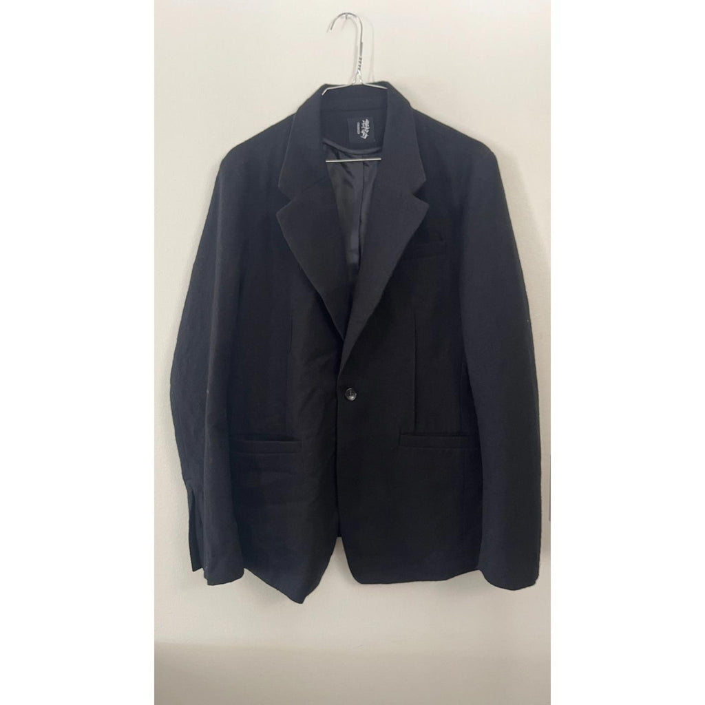 CROQUIS BLACK BOILED WOOL 1 BUTTON BLAZER hanging on a hanger against a plain background.