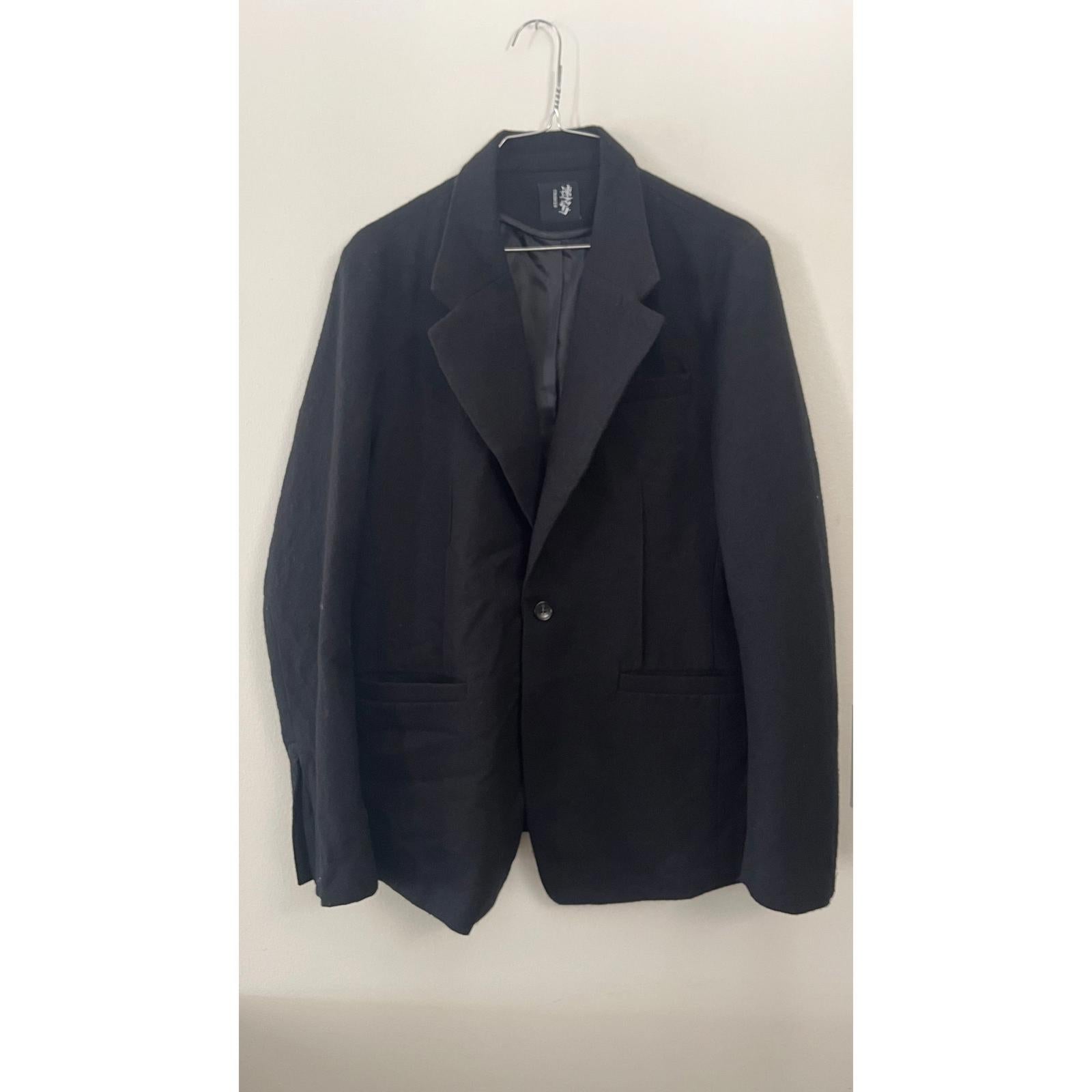 CROQUIS BLACK BOILED WOOL 1 BUTTON BLAZER hanging on a hanger against a plain background.