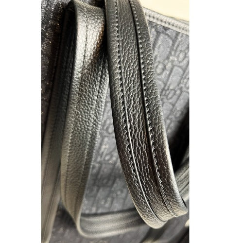 Close-up of the strap detail on a CHRISTIAN DIOR KIM JONES BLACK OBLIQUE MONOGRAM TOTE BAG.