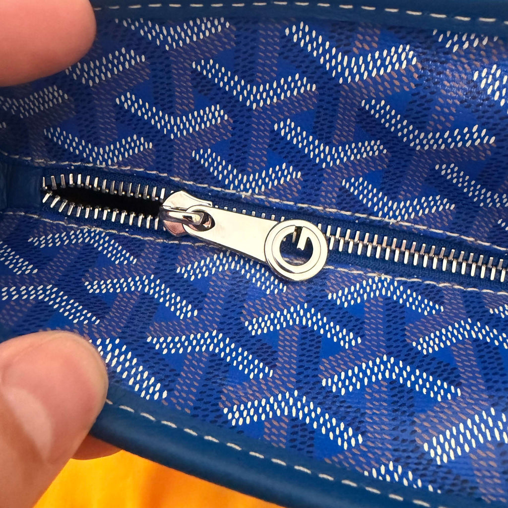Interior zip pocket of the Goyard Artois MM Tote Bag- Goyardine featuring blue patterned lining.