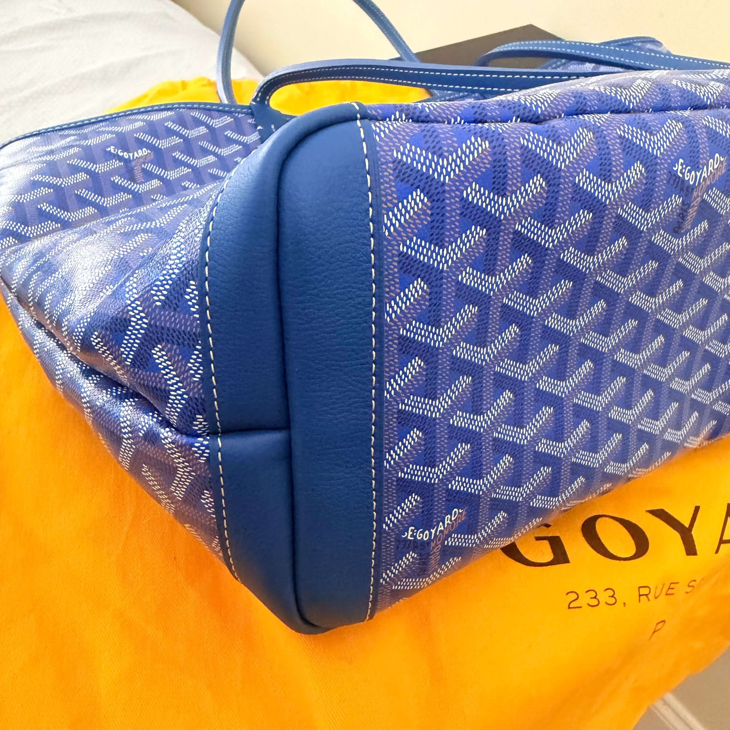 Goyard Artois MM Tote Bag- Goyardine displayed against a vibrant orange dust bag.