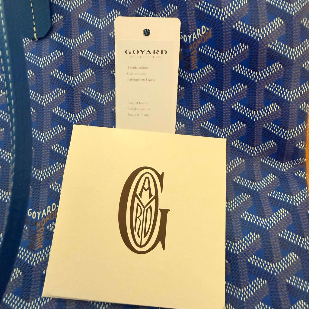 Interior details of Goyard Artois MM Tote Bag- Goyardine showing care card and brand logo.