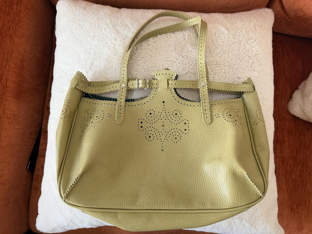 JAMIN PUECH DELICATE DETAIL HANDBAG in vibrant chartreuse with lace perforated detail on a soft leather surface.