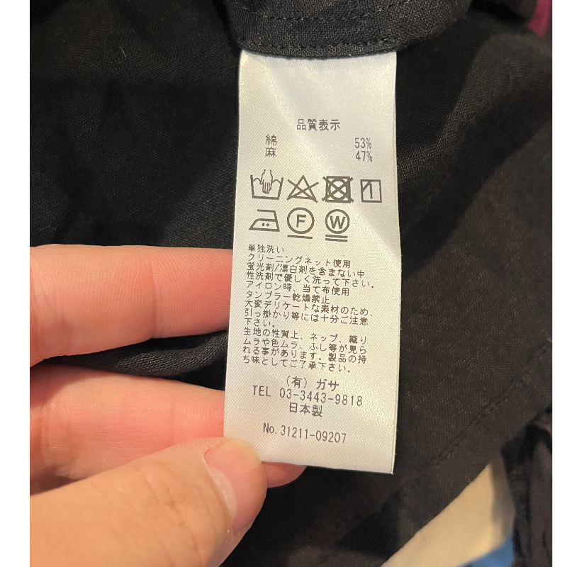 Care label of NATIVE VILLAGE LINEN BOHO SHEER BLOUSE showing fabric content and washing instructions.