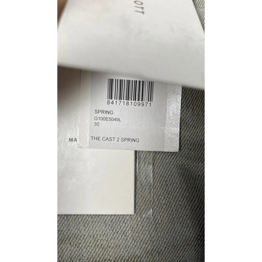 Close-up of the tag showing JOHN ELLIOTT THE CAST 2 SPRING DIRTY JEANS, marked size 30, authentic label and barcode.