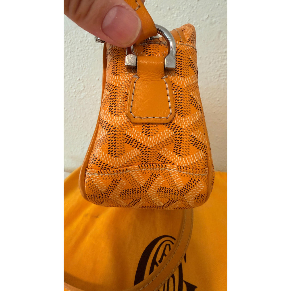 Detail of the handle of the GOYARD YELLOW CAP VERT CROSSBODY BAG showcasing the vibrant yellow Goyardine pattern.