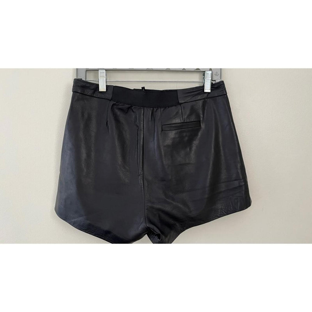 MAJE LAMBSKIN LEATHER BIKER SHORTS black leather shorts with pockets hanging on a rack.