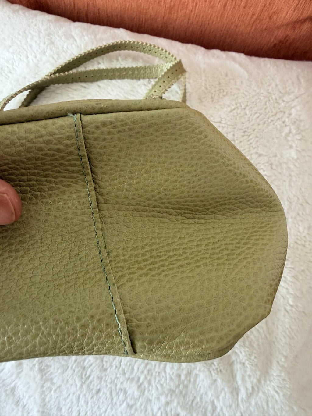 Close-up of the JAMIN PUECH DELICATE DETAIL HANDBAG showcasing its textured leather and unique shape.