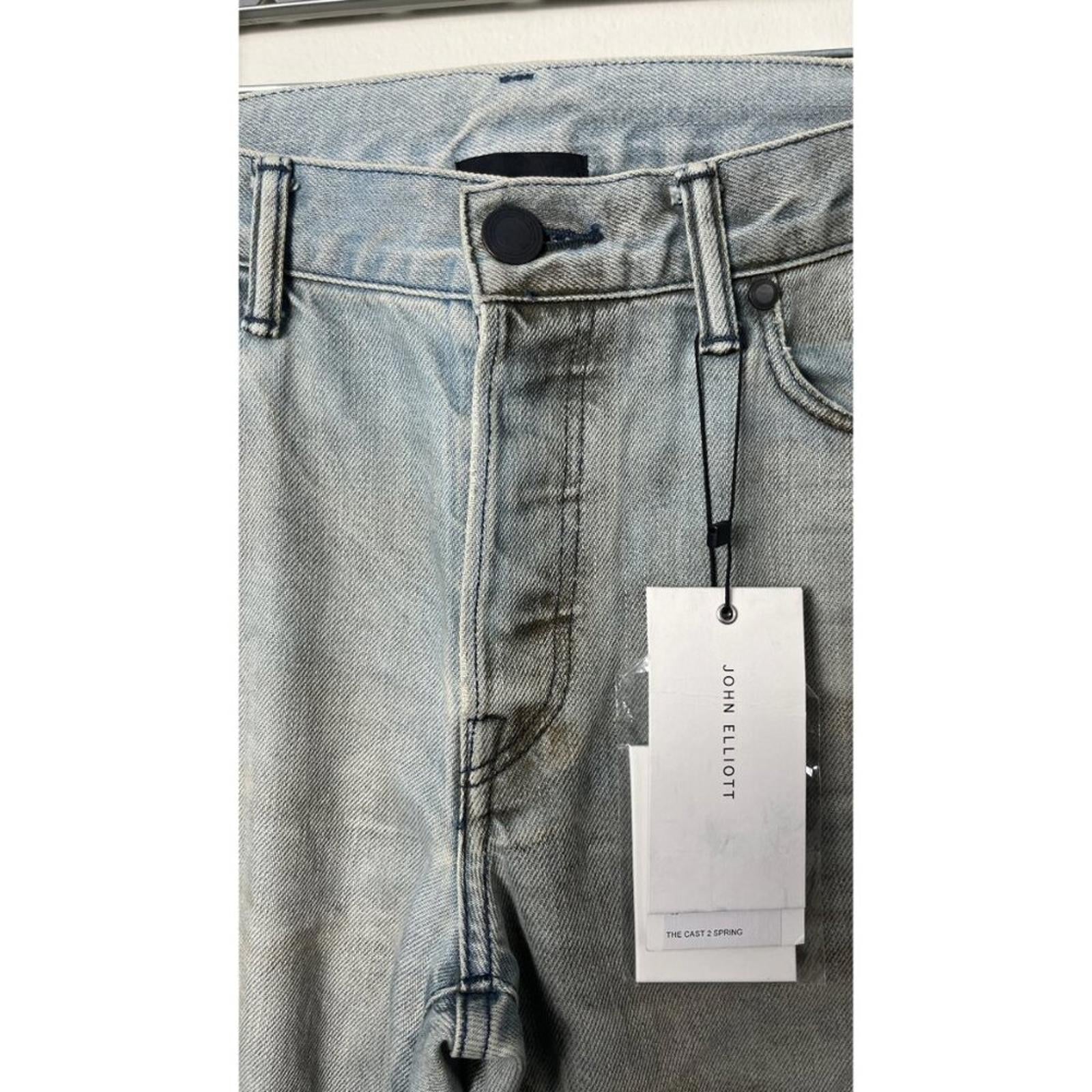 JOHN ELLIOTT THE CAST 2 SPRING DIRTY JEANS showcasing the button fly and hang tag in vintage wash.