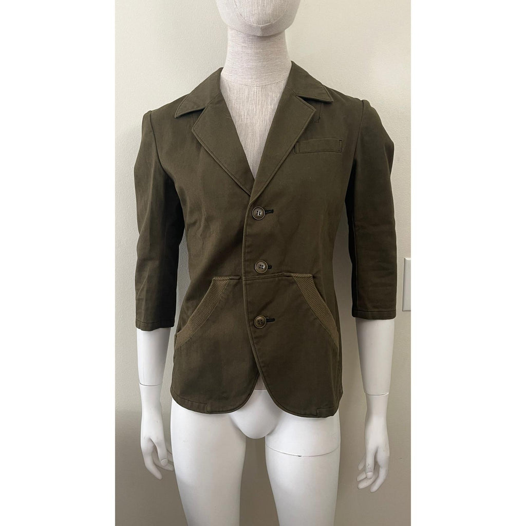 Y'S YOHJI YAMAMOTO GREEN ARMY JACKET displayed on a mannequin showcasing its stylish design and button details.